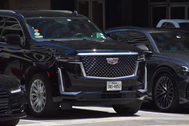 Houston, TX USA - 5/15/2024 - A portrait of a black Cadillac Escalade SUV at a stop light in a downtown district